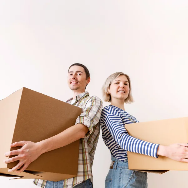 Un homme et une femme portent des cartons lors d'un déménagement résidentiel.