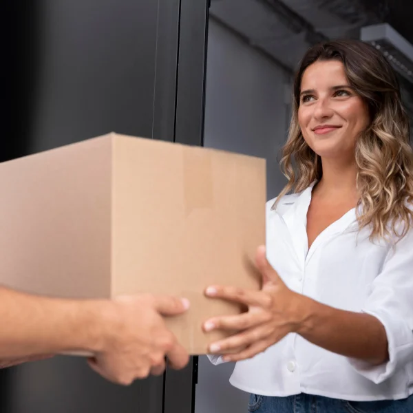 Une femme remet une boîte à un homme, illustrant un emballage sécuritaire.